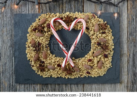 Granola Wreath on Slate and Dark Wooden Background with Candy Canes in Shape of a Heart