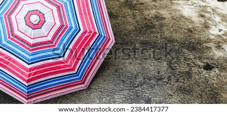 Umbrella on cement floor after rain.