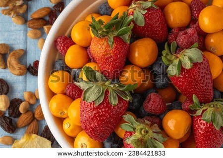 Close-up top view of a bowl of healthy fruit with granola on the side