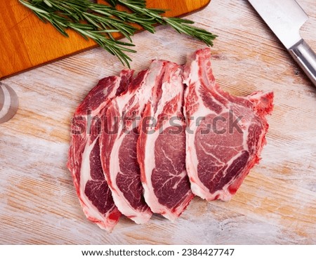 Close up of raw pork's chops on wooden table, no people