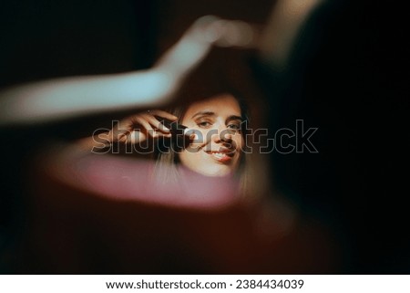 
Woman Using Highlighter on Her Cheekbones Looking in the Mirror
Girl using cosmetic product to enhance her glow 
