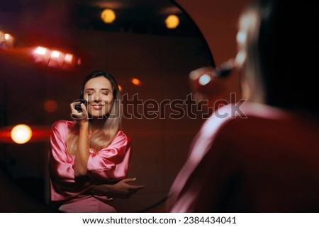 
Woman Using Highlighter on Her Cheekbones Looking in the Mirror
Girl using cosmetic product to enhance her glow 
