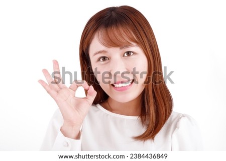A young woman making OK gestures