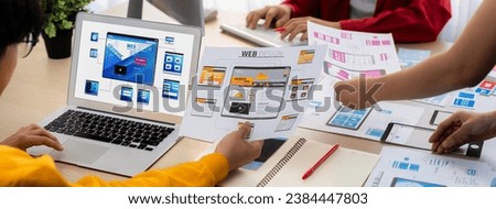 Panorama banner of startup UX developer or company employee design user interface or UI prototype for mobile application or website software with software display on laptop monitor in office. Synergic