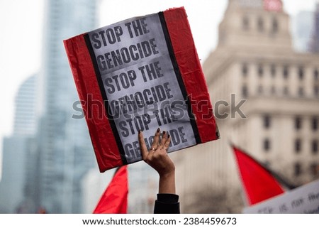 Person  holds up a sign saying Stop the Genocide  at a Palestinian demonstration Toronto Canada against the war in Gaza Royalty-Free Stock Photo #2384459673
