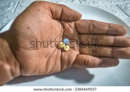 hand carrying three pills for schizophrenic sufferers Royalty-Free Stock Photo #2384469037