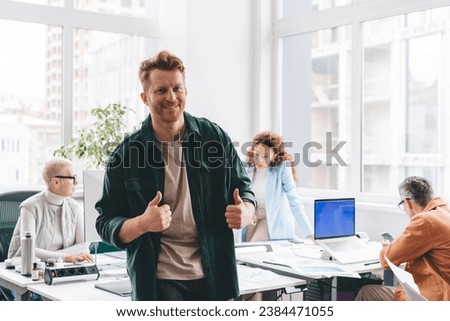 Happy man showing thumbs up during conference in office