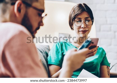  millennial man and woman using smartphone gadgets indoors