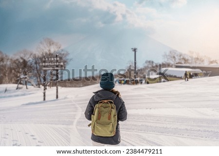 Woman tourist Visiting in Niseko, Traveler in Sweater sightseeing Yotei Mountain with Snow in winter season. landmark and popular for attractions in Hokkaido, Japan. Travel and Vacation concept Royalty-Free Stock Photo #2384479211