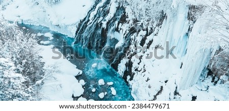 Shirahige Waterfall with Snow in winter, Biei river flow into Blue Pond. landmark and popular for attractions in Hokkaido, Japan. Travel and Vacation concept Royalty-Free Stock Photo #2384479671
