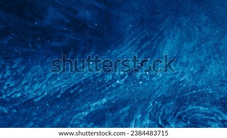 Dust particles background. Ethereal aura. Light shiny glitter sparks ink fluid spreading in dark blue abstract hypnotic captivating cosmic art.