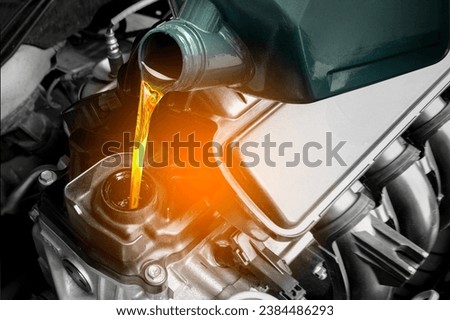 Refueling and pouring oil quality into the engine motor car Transmission and Maintenance Gear .Energy fuel concept. Royalty-Free Stock Photo #2384486293