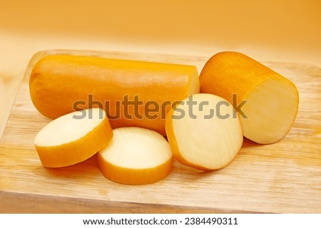 SLICED PROVOLONE CHEESE ON WOODEN BOARD Royalty-Free Stock Photo #2384490311