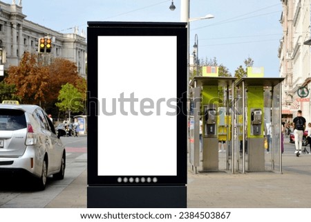 white blank advertising billboard. street mockup panel in Vienna. digital lightbox poster ad banner board. green urban downtown street background. vertical format sign. bus shelter advertising