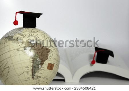 A globe with a school cap and a school cap on a book.
Global education concept.