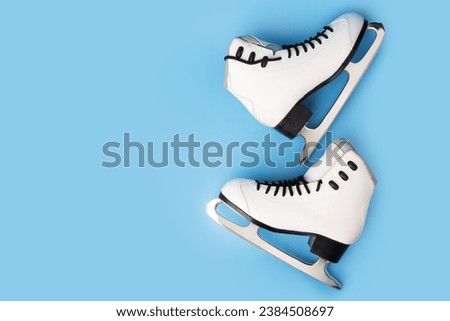 Pair of ice skates on a cool blue background, winter sports accessories Royalty-Free Stock Photo #2384508697