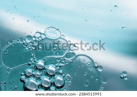 Blue pastel drops of oil or serum texture background. Abstract yellow fluid with bubbles Royalty-Free Stock Photo #2384515991