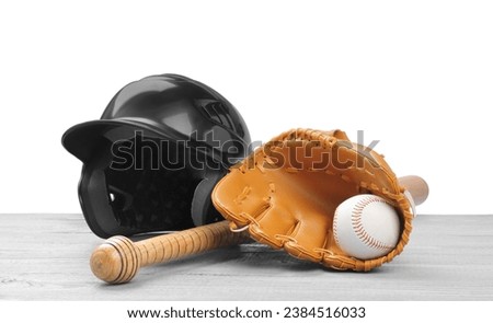 Baseball glove, bat, ball and batting helmet on light grey wooden table against white background