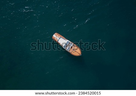  luxury wooden boat is located on the water, top view. Expensive wooden boat parking on the water, top view. Royalty-Free Stock Photo #2384520015