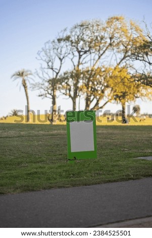 Sunny Day Mock-Up of a Green Sign on the Grass