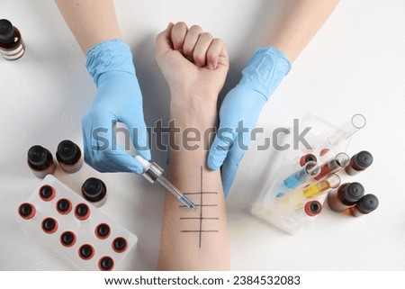 Doctor doing skin allergy test at light table, top view Royalty-Free Stock Photo #2384532083