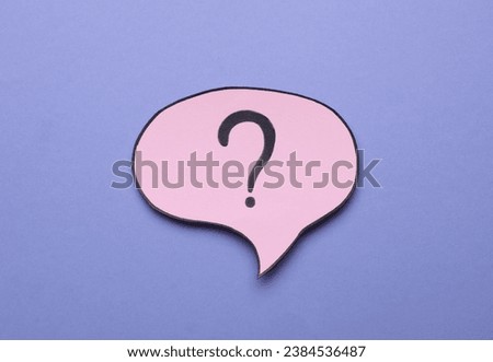 Paper speech bubble with question mark on violet background, above view
