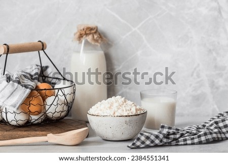 Fresh dairy products, milk, cottage cheese, eggs in stylish ceramic dishes on a gray background. The concept of natural, dietary nutrition. Useful products.