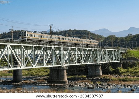 Joetsu Line local train crossing the Tone River iron bridge Royalty-Free Stock Photo #2384587987
