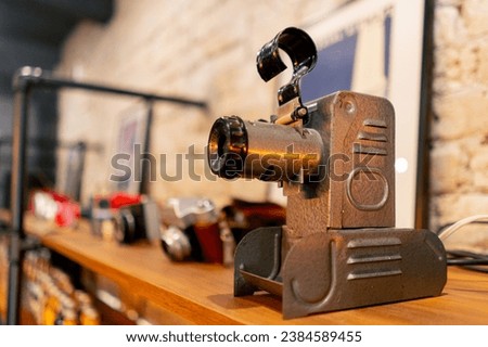 A rare antique projection device for broadcasting films stands on a wooden shelf in an antiques store