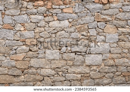 yellow beige natural stone wall of different sized stones, traditional crafts