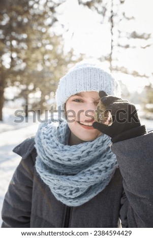 Happy family in the winter forest. High quality photo. The girl holds a piece of ice in front of her. enjoy winter