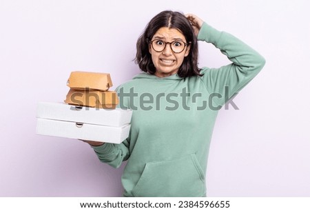 pretty young woman feeling stressed, anxious or scared, with hands on head. fast food take away concept