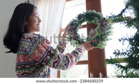Woman decorating beautiful Christmas wreath
