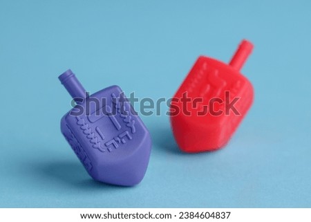 Colorful dreidels on light blue background, space for text. Traditional Hanukkah game