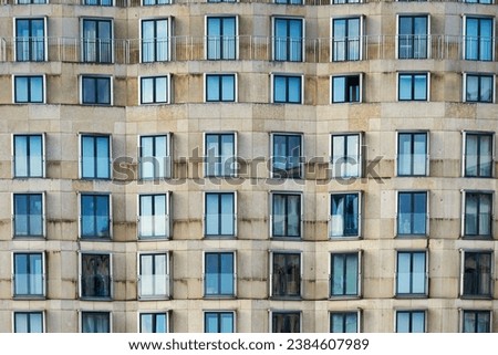 Front view pattern of windows or casement on a modern building. Contemporary exterior with pattern of fenestra or fanlight conveys rental crisis in all major capitals or real estate market concept Royalty-Free Stock Photo #2384607989