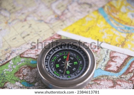 Compass and map. The magnetic compass is located on a topographic map.