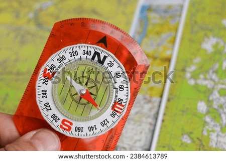 Compass and map. The magnetic compass is located on a topographic map.