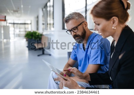 Pharmaceutical sales representative talking with doctor in medical building. Ambitious female sales representative presenting new medication. Woman business leader. Royalty-Free Stock Photo #2384634461