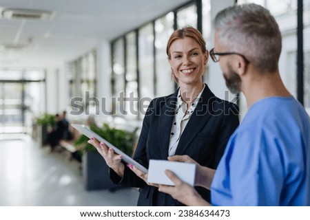 Pharmaceutical sales representative talking with doctor in medical building. Ambitious female hospital director consulting with healtcare staff. Woman business leader. Royalty-Free Stock Photo #2384634473