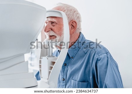Close up photo of a senior male patient undergoing vision examination. Myopia eyesight loss prevention. Cataract illness treatment with modern equipment Royalty-Free Stock Photo #2384634737