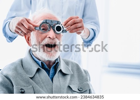 Enthusiastic elderly male patient wearing ophthalmic glasses for vision check, selecting eye sight lenses, spectacles. Ophthalmology occupation concept Royalty-Free Stock Photo #2384634835