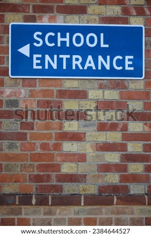 School Entrance Sign On Brick Wall Of School Building