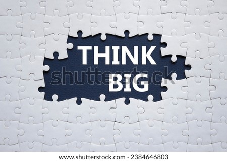 Think big symbol. White puzzle with words Think big. Beautiful dark blue background. Business and Think big concept. Copy space.