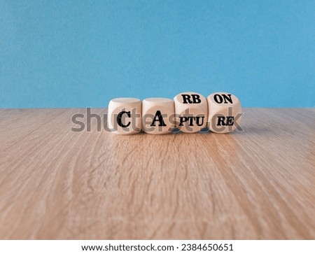 Carbon capture symbol. Turned wooden cubes and changed the concept word Carbon to Capture. Beautiful wooden table blue background. Business ecological carbon capture concept. Copy space. Royalty-Free Stock Photo #2384650651