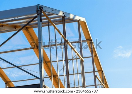 Steel building framework frame beams under construction for an industrial commercial building Royalty-Free Stock Photo #2384652737