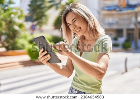 Young woman smiling confident using touchpad at park