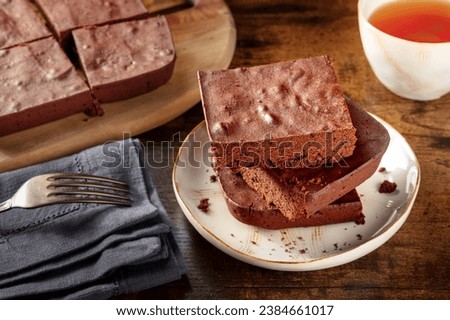Chocolate brownie with tea, simple coffee cake, on a dark rustic wooden background, gourmet breakfast