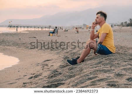 Man sits on the beach and looks at the sea in Alanya city, Turkey. Travelling or vacation concept
