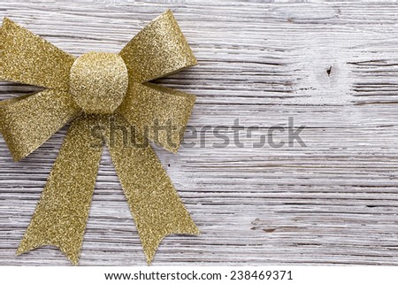 Christmas bow golden color. On colored paper background.