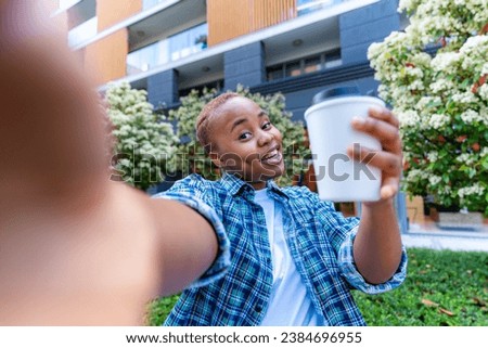 portrait of a young woman at college taking a picture with her coffee after a study session at the library Royalty-Free Stock Photo #2384696955